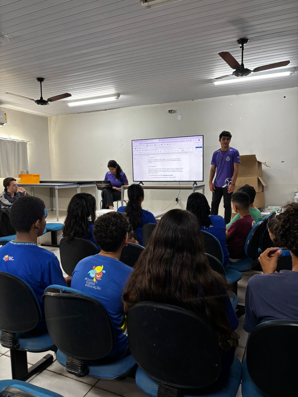 Integrantes da Dumonters realizando uma formação para a comunidade acadêmica de escolas públicas